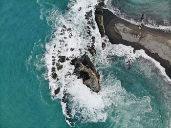 High angle view of waves splashing on rock