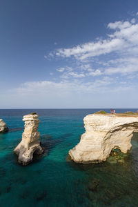 Scenic view of light blue and crystal clear sea against white clouds sky