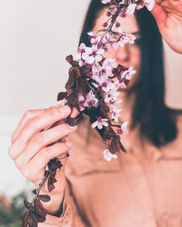 Close-up of woman holding red flowering plant