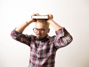 Portrait of young man standing against white background