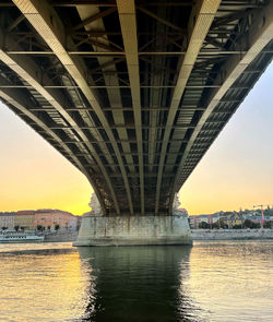 Bridge over river against sky during sunset