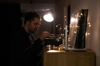 Side view of man holding lit candles