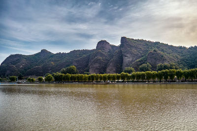 Scenic view of lake by mountains against sky