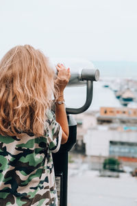 Woman looks through binoculars at the sea. traveler vacation holiday concept. new travel destination