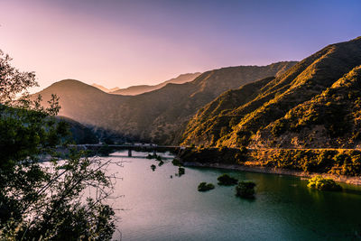 Scenic view of lake by mountains against sky