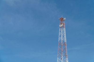 Low angle view of communications tower against blue sky