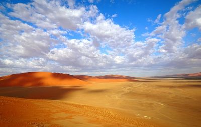 Scenic view of desert against cloudy sky