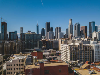 Modern buildings in city against clear blue sky