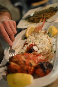 Close-up of man preparing food in plate