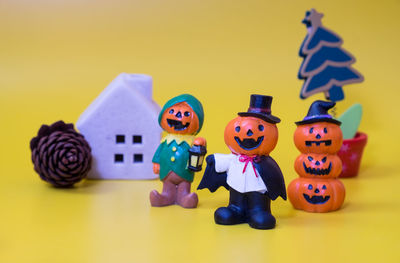 Close-up of toys on table against yellow background
