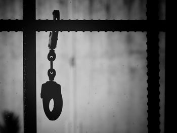 Close-up of handcuffs hanging from metal in prison