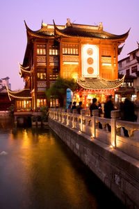 Illuminated building against sky at dusk