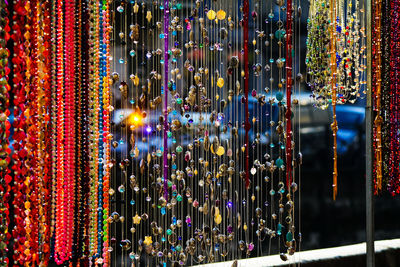 Close-up of illuminated decorations hanging in store for sale