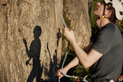 Male rock climber belaying