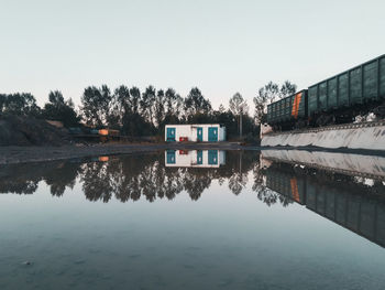 Reflection of building in lake against clear sky