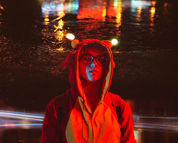 Portrait of young woman looking away at night