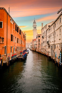 Characteristic canal of venice at sunset with famous crooked bell tower in the background