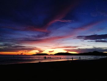Scenic view of beach against sky at sunset