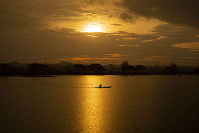 This photo taken on august 12, 2021 show a fisherman rowing his boat at sunset in ihokseumawe,aceh.