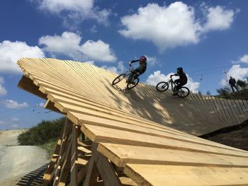 Man riding bicycle in bikepark against sky