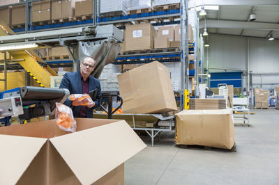 Manager checking the packaging of plastic connectors in plastics factory