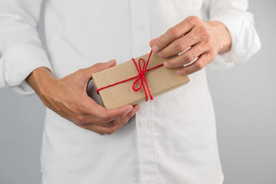 Midsection of man holding paper in box