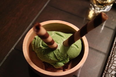High angle view of green tea ice cream in bowl on table