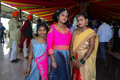 Portrait of a smiling girl standing against people