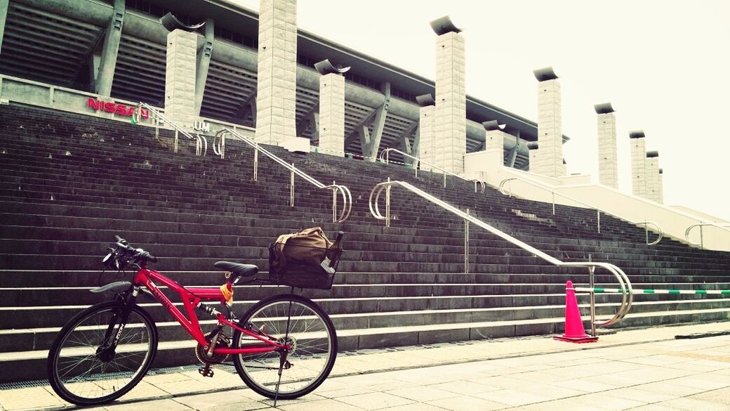 bicycle, architecture, built structure, building exterior, transportation, mode of transport, land vehicle, parked, railing, stationary, parking, city, steps, street, day, building, travel, red, outdoors, cobblestone