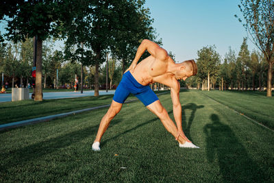 Full length of man with arms raised on grass