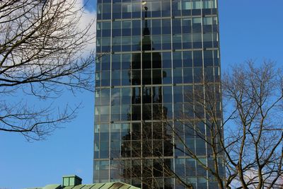 Low angle view of modern building against blue sky