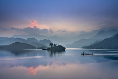 Scenic view of lake against mountains during sunset