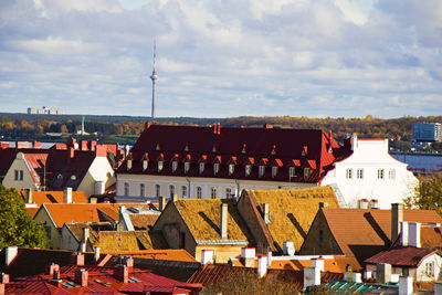 Houses in town against cloudy sky