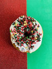 Donut with sprinkles on red and green background