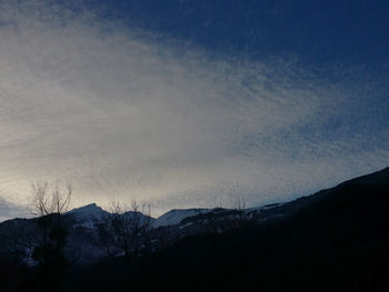 Silhouette of mountain range against cloudy sky