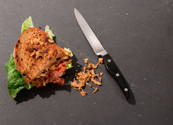 High angle view of sandwich with kitchen knife on table