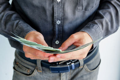 Midsection of man holding mobile phone