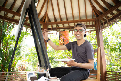 Portrait of young man sitting on hammock