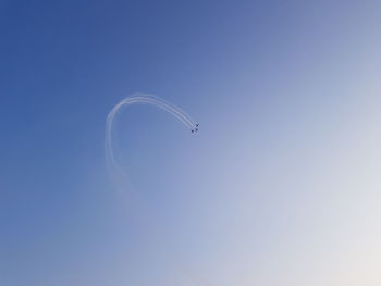 Low angle view of vapor trail against clear blue sky