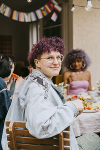 Portrait of smiling non-binary person during party in back yard