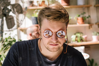 Young man wearing sunglasses indoors