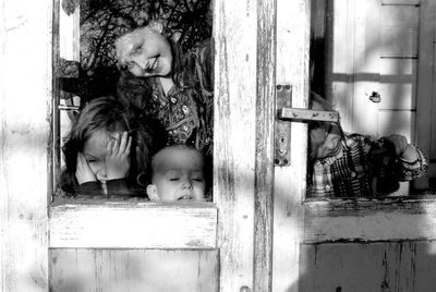 Close-up of children looking through window
