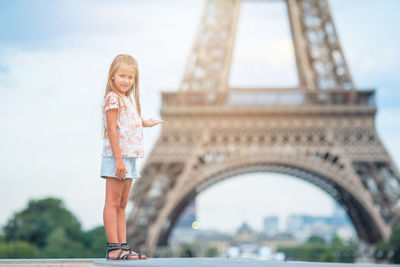 Portrait of girl standing in front of eiffel tower
