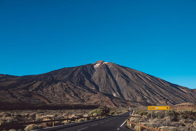 Mountain road against clear blue sky