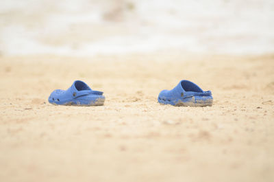 Close-up of shoes on sand