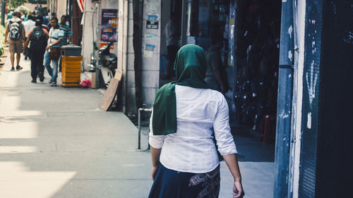 Rear view of muslim women walking on street