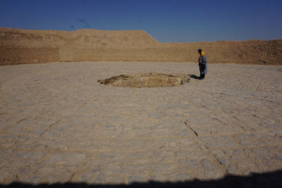 Full length of man standing on desert against sky