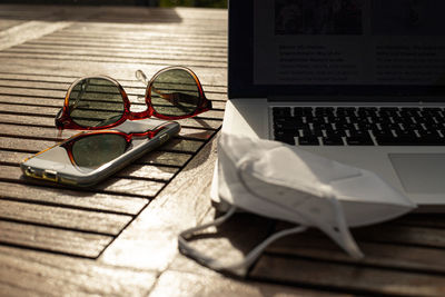 Close-up of sunglasses and laptop on table