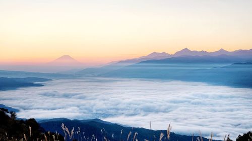 Scenic view of sea and mountains against sky during sunset