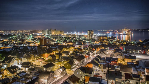 High angle view of illuminated cityscape against sky at night